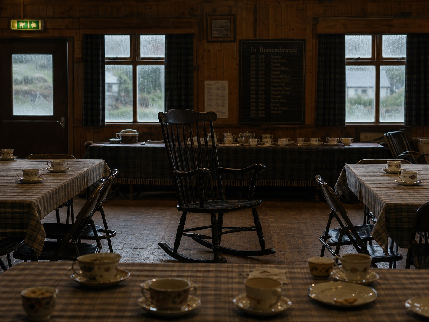 A wooden village hall interior with a single rocking chair in the center of a circle of empty tea cups.